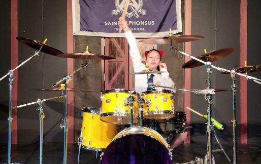 Sixth-grade student performing at her yellow drum set