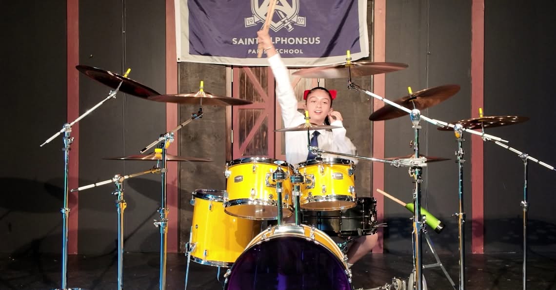 Sixth-grade student performing at her yellow drum set